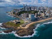 Vista panorâmica de Salvador, Bahia, com céu nublado, ilustrando a previsão de calor e possibilidade de chuva para 24 e 25 de outubro de 2026.